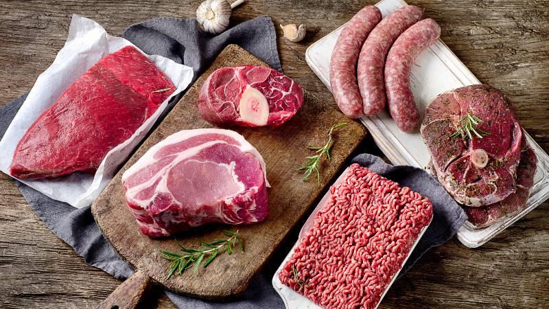 varieties of red meat on wooden cutting boards